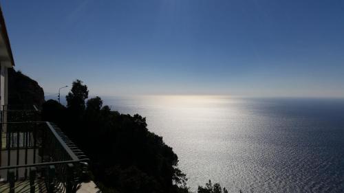 a view of a body of water with the sun in the sky at Le Cicale - Apartments in Conca dei Marini