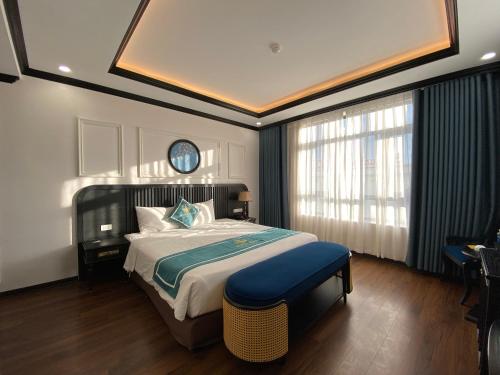 a bedroom with a large bed and a clock on the ceiling at Moma Paris Hotel Ninh Bình in Ninh Binh