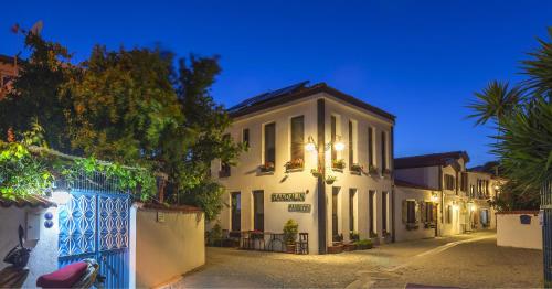 a white building on a street at night at Mandalin Pansiyon in Siğacık