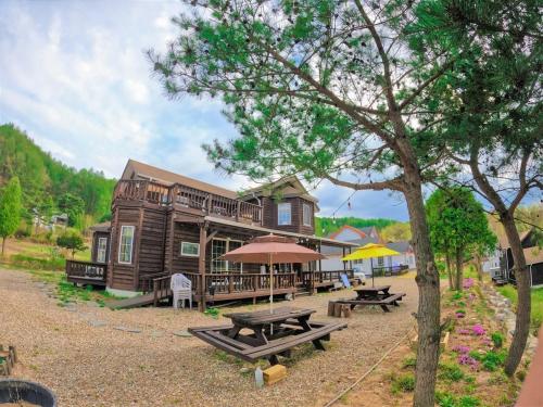 a log cabin with picnic tables in front of it at Morning Sound in Pyeongchang