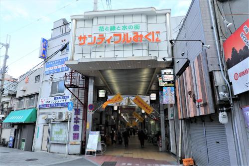 an alleyway in a city with people walking down it at Astil Hotel Shinosaka Precious in Osaka
