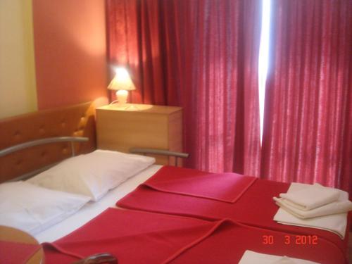 a bedroom with a bed with a red blanket on it at Aparthotel Pecic in Gradac