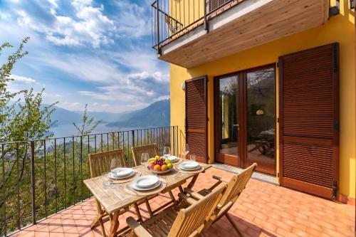 a wooden table and chairs on a deck with a view at Alto Perledo Terrazzo in Perledo