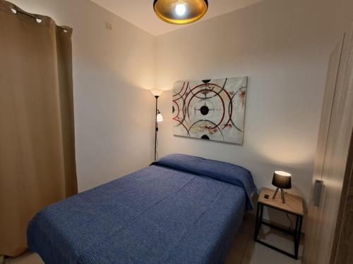 a bedroom with a blue bed and a lamp at Lanyard Hitch Court in Marsaxlokk