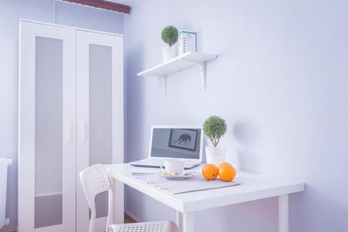 a white desk with a laptop and oranges on it at Kujawska Rooms in Lublin