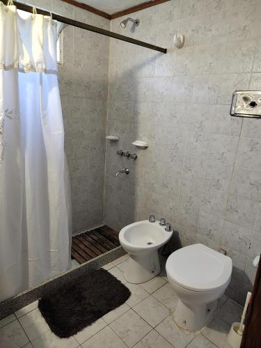 a bathroom with a toilet and a shower at Pinos del Virrey I in Valle Hermoso