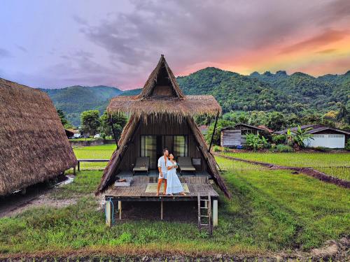 a woman standing on a house in a field at Khao Kiang Na เขา เคียง นา in Ban Muang Kut