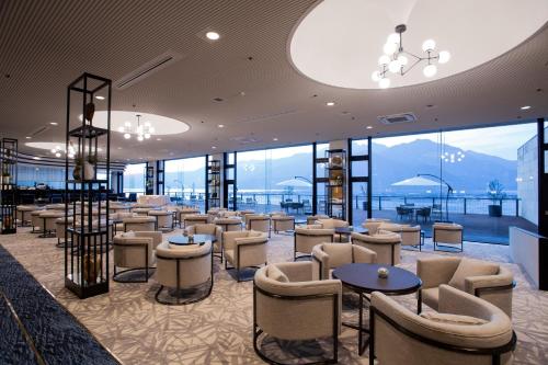 a hotel lobby with chairs and tables and windows at Aki Grand Hotel & Spa in Miyajima