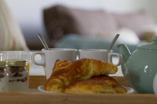 a plate of croissants and two cups on a table at Rooms At Aysgarth ,Town Ends in Aysgarth