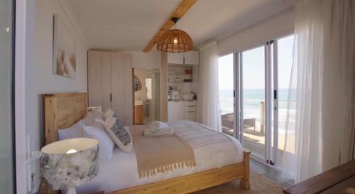a bedroom with a bed with a view of the ocean at Khayalena Beach House - Tides Reach in Umdloti