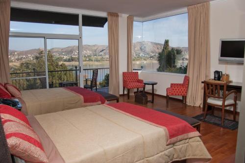 a hotel room with two beds and a large window at Tagore Suites Hotel in Villa Carlos Paz