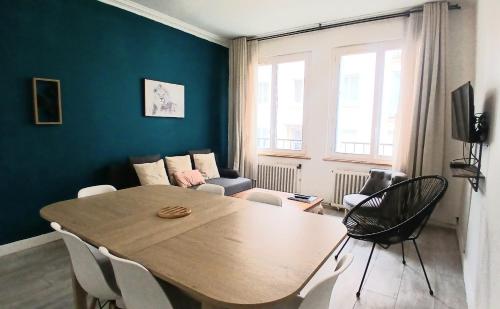 a living room with a table and a couch at Ty'brestoise proche centre - jardin- parking gratuit in Brest