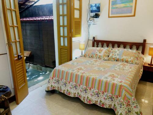 1 dormitorio con 1 cama en una habitación con ventana en Casa do Jardim, en Río de Janeiro