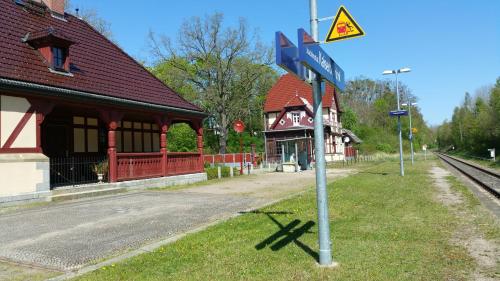a blue street sign in front of a train station at Bungalows am Grimnitzsee in Joachimsthal