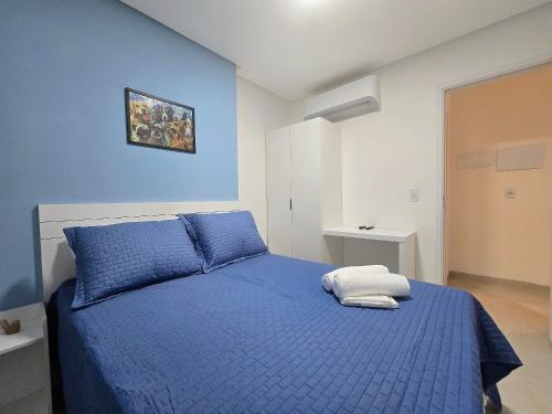 a blue bedroom with a bed with a blue blanket at Life Center in Caruaru