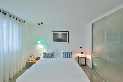 a bedroom with a large white bed with blue pillows at Alilass Hotel in Istanbul