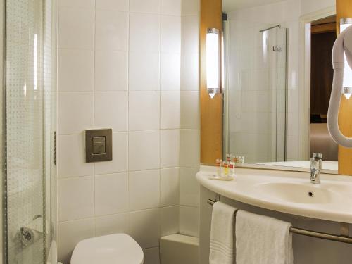 a bathroom with a sink and a toilet and a shower at Ibis Lagos Ikeja in Ikeja