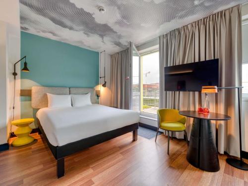 a hotel room with a bed and a table at ibis Berlin Kurfuerstendamm in Berlin