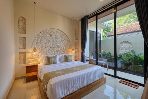 a bedroom with a large bed and a large window at Rest U Guest House in Nusa Penida