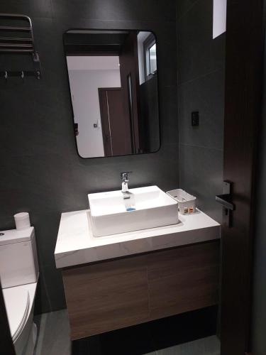 a bathroom with a white sink and a mirror at Maison Art in Quy Nhon