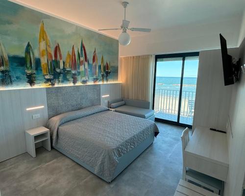 a bedroom with a bed and a view of the ocean at Hotel Royal in Cesenatico
