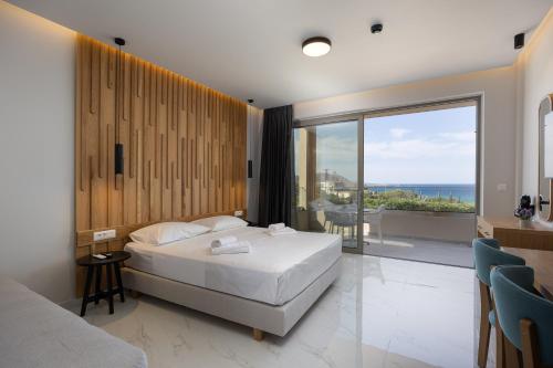 a bedroom with a bed and a view of the ocean at Falasarna Bay Hotel in Falasarna