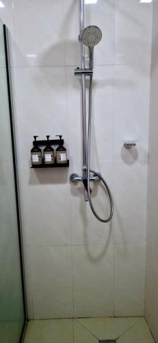 eine Dusche in einem Badezimmer mit zwei Flaschen an der Wand in der Unterkunft Sunset Villas in Korotogo