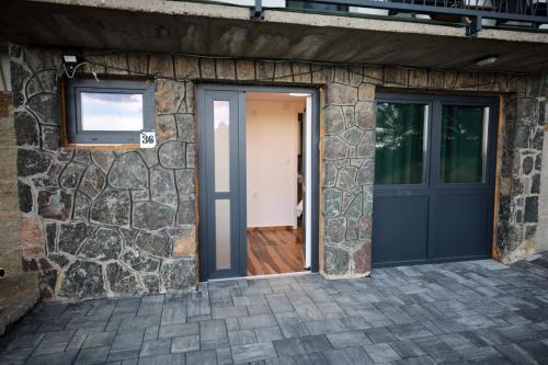 a door to a house with a stone wall at Leona in Kamešnica