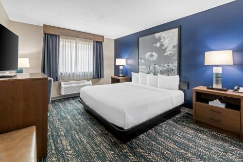 a hotel room with a bed and a flat screen tv at Super 8 by Wyndham Perham in Perham