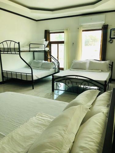 a bedroom with three beds and a window at Safe Haven Residence in Talibon
