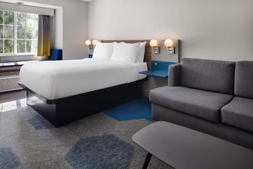 a hotel room with a bed and a couch at Microtel Inn & Suites - Kearney in Kearney