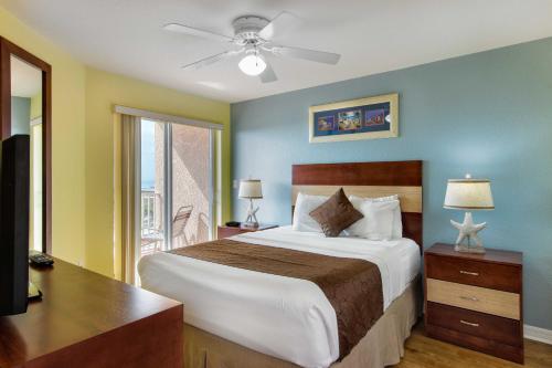 a bedroom with a bed and a desk and a window at Surf Beach Resort by Sunsational Beach Rentals in St Pete Beach