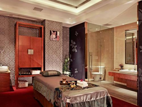 a bedroom with a bed and a bathroom with a tub at Pullman Xiamen Powerlong in Xiamen