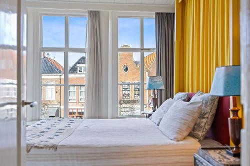 a bedroom with a bed and a large window at Gentle in Bolsward