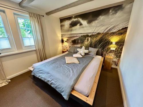 a bedroom with a bed with a painting on the wall at Fachwerkliebe Villa Mia in Olsberg