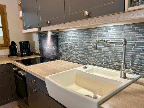a kitchen with a white sink and a brick wall at Fachwerkliebe Villa Mia in Olsberg