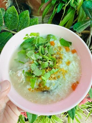 a bowl of soup with greens on top of it at NewDhara Place Lom Sak Hotel in Phetchabun