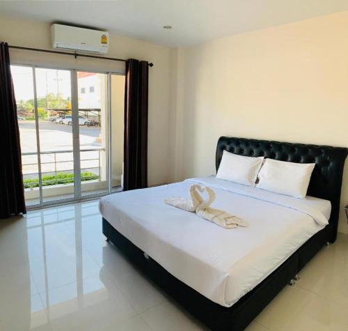 a bedroom with a large bed with a large window at NewDhara Place Lom Sak Hotel in Phetchabun