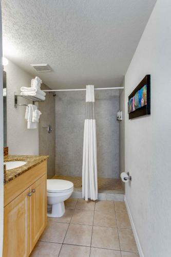 a bathroom with a toilet and a sink and a shower at Surf Beach Treasure Island Resort in St. Pete Beach