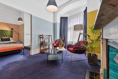 a bedroom with a bed and a living room at Hotel Harry, an Ascend Collection Hotel in Sydney