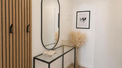 a mirror on a wall next to a glass table at Ferienwohnung an der Steinmauer in Bad Kissingen