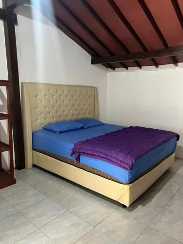 a large bed in a room with a purple mattress at Tiara Homestay Banyuwangi Near train Station in Banyuwangi