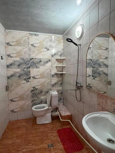 a bathroom with a toilet and a sink and a tub at Квартира у бульвара 1 in Batumi