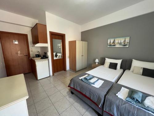 a small bedroom with two beds and a kitchen at Heaven Studios & Apartments in Stalís