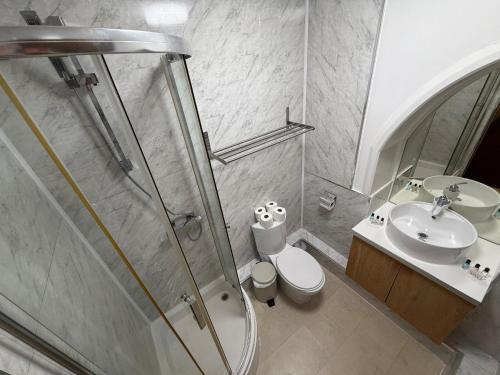 a bathroom with a shower and a toilet and a sink at Milverton Court by OYO in Manchester