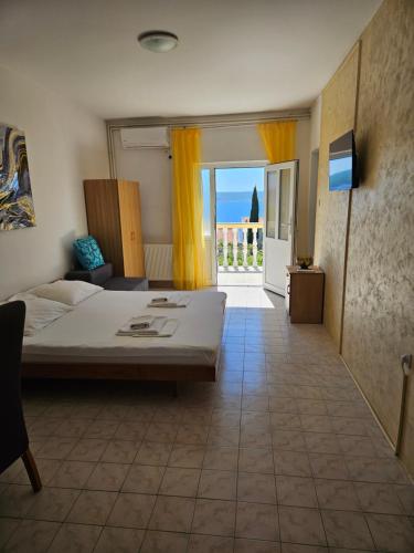 a bedroom with a bed and a view of the ocean at Apartmani Štefica in Dramalj