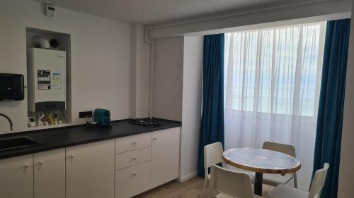 a kitchen with a small table and a window at Ella Apart Hotel in Constanţa