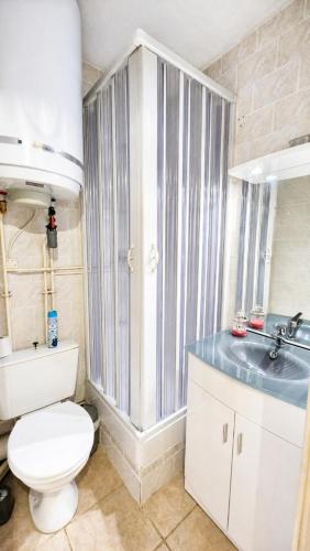 a bathroom with a toilet and a sink at Cozy studio in La Foux