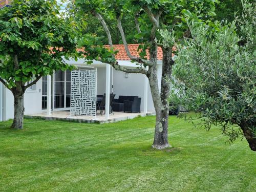 a white house with trees in the yard at Bernard in Soustons