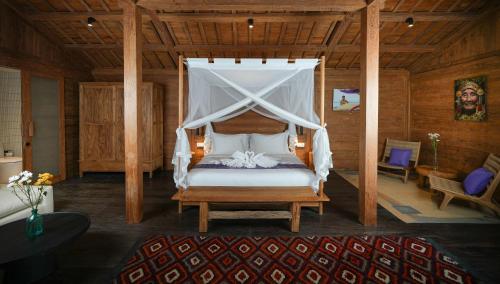 a bedroom with a bed with a canopy at Villa Purple in Tabanan